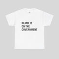 Weißes T-Shirt mit "Blame It On The Government" Druck von Printify, bequemer Schnitt, ideal für Alltag und Freizeit.